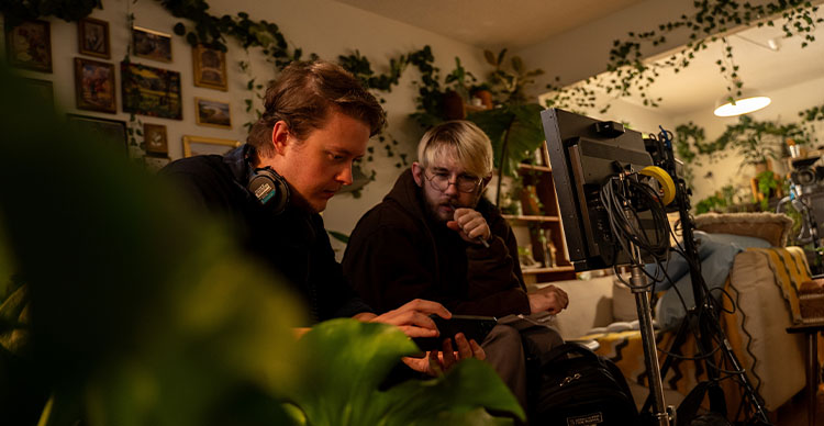 Director Elias Olsson and script supervisor Rylan Cain reviewing notes on set during the filming of The Beanstalk.
