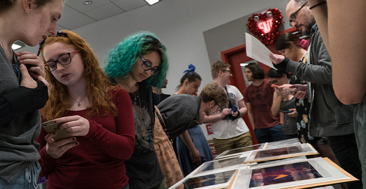 Animation students reviewing artwork together during a collaborative classroom critique.